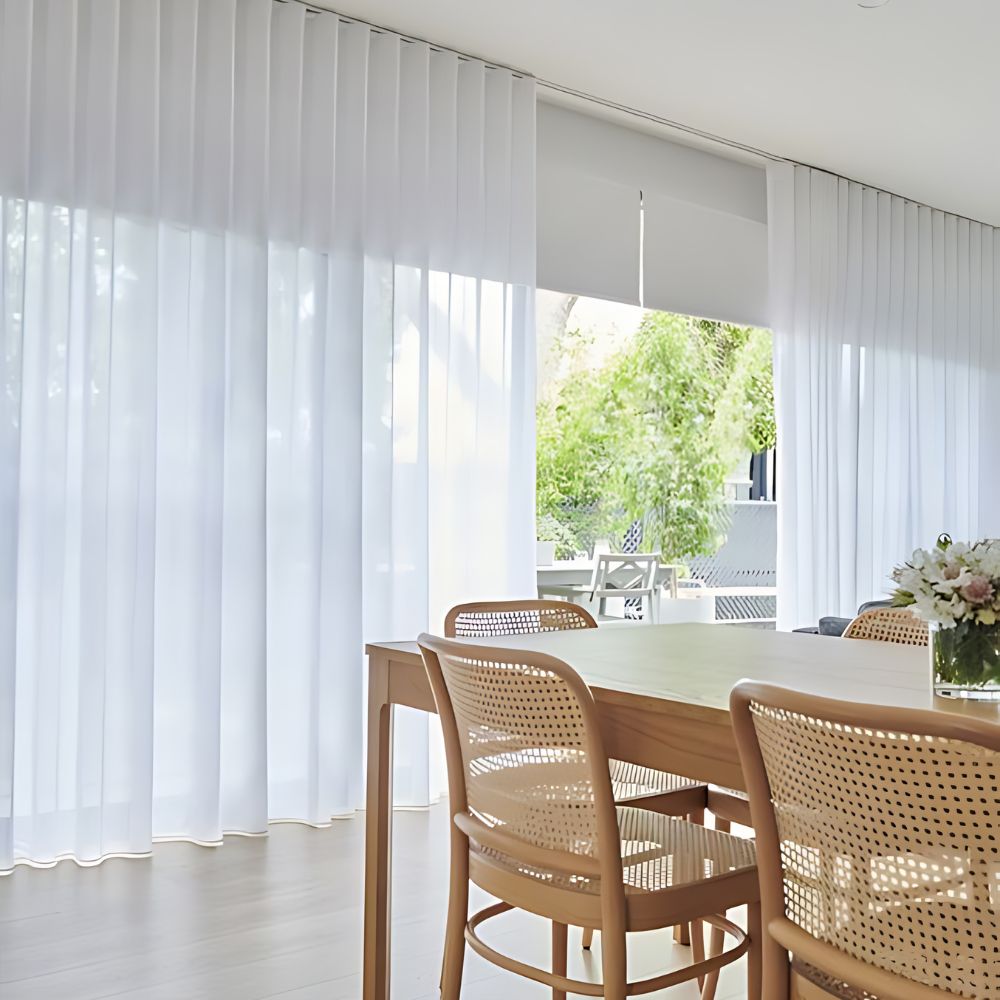 White sheer curtains beside a light-filled dining space